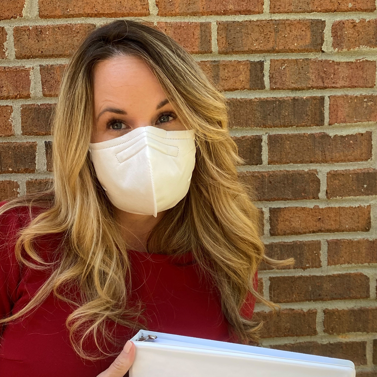 A photo of Autumn Blackledge wearing a white mask and red shirt