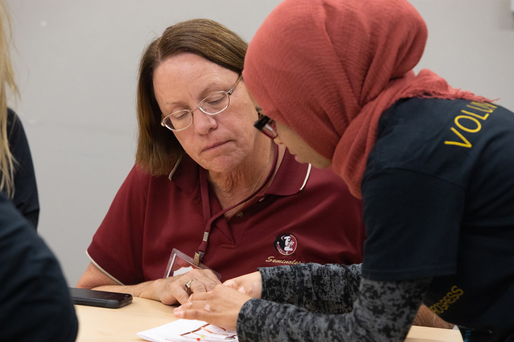 Two women looking at a circuit board on a table