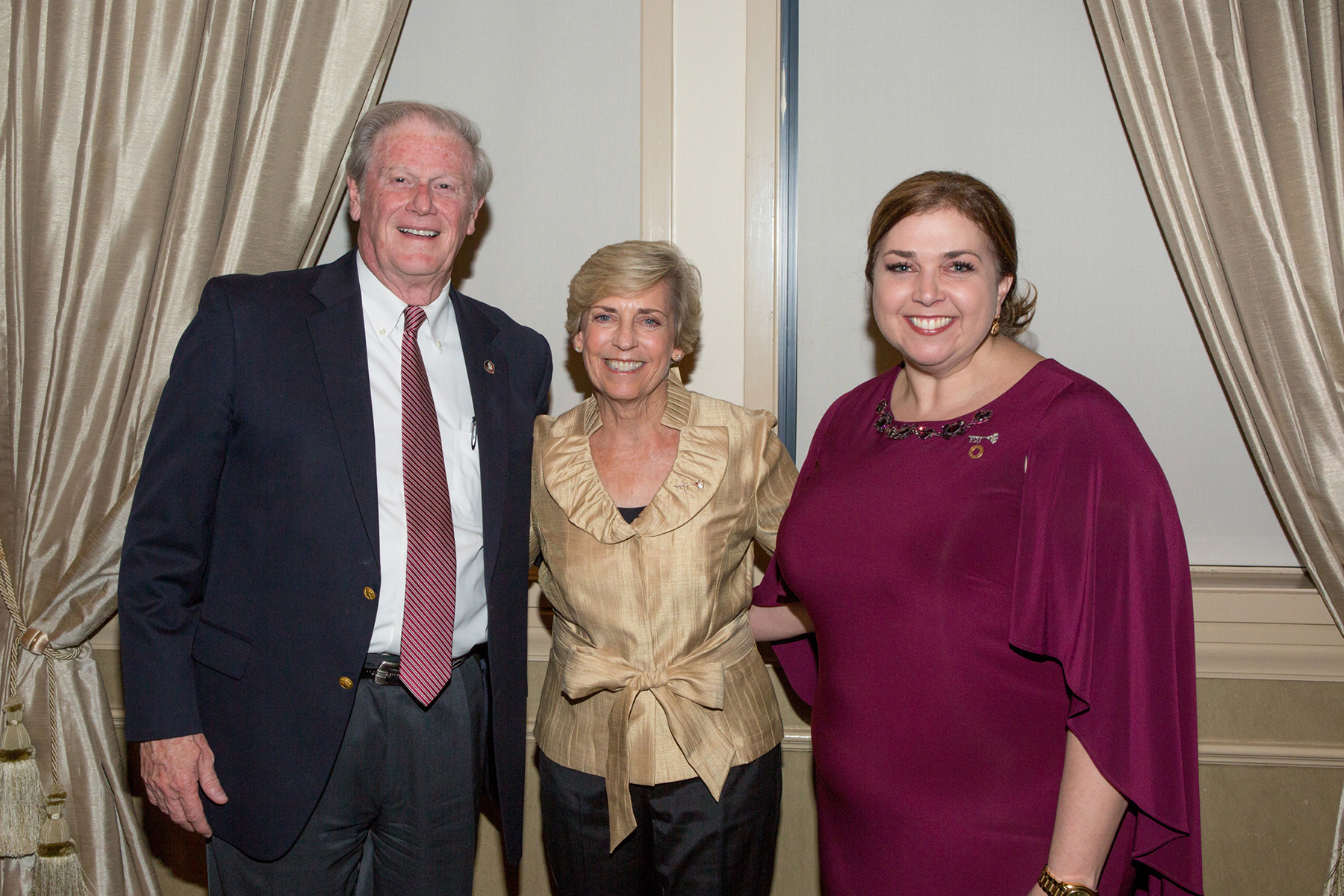 A photo of three people, smiling at the camera