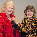 Two women holding an award