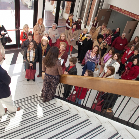 An overhead shot from a stairwell of a group of women gathered at the foot of the stairs